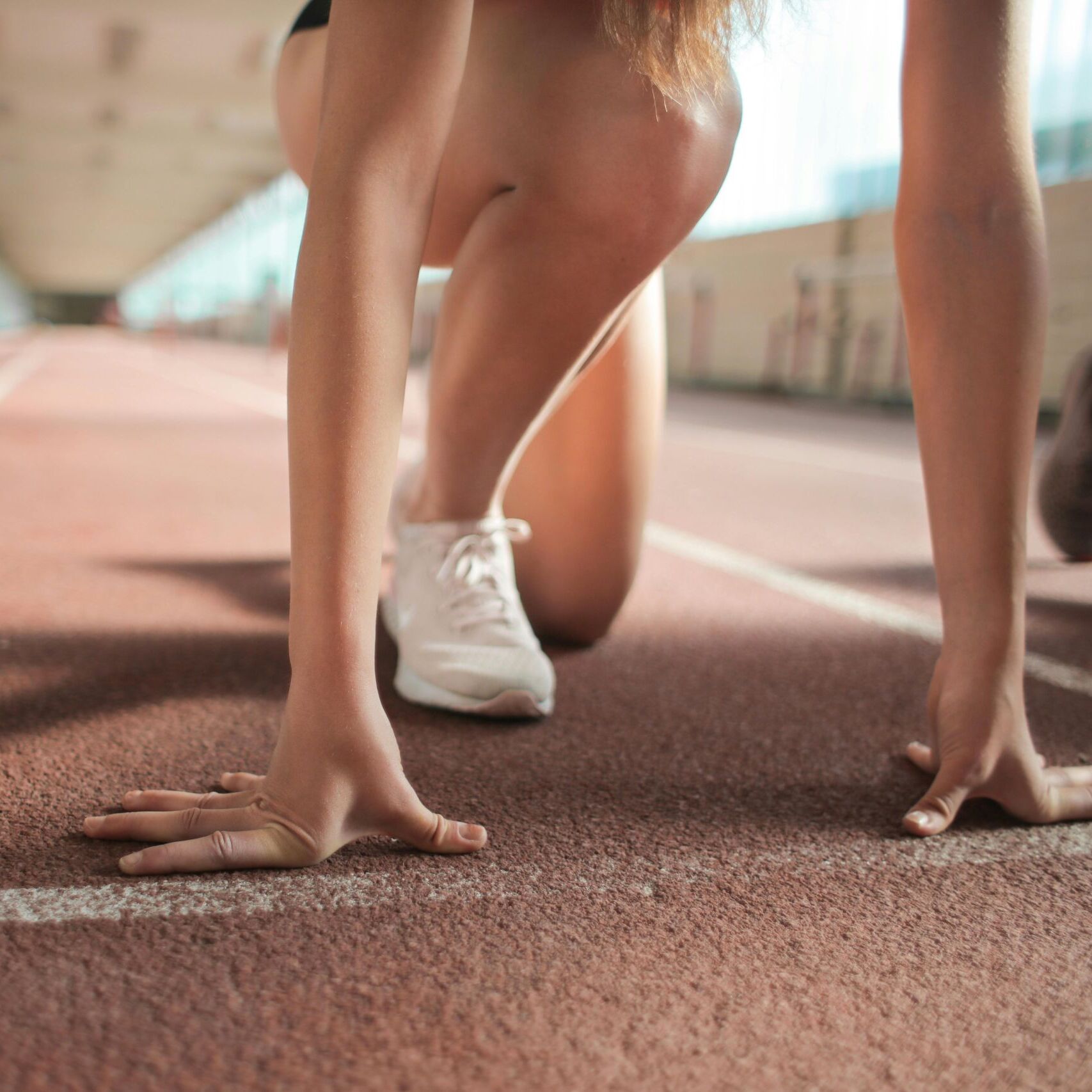 Athlete at starting blocks on track, symbolizing sportainment industry strategy