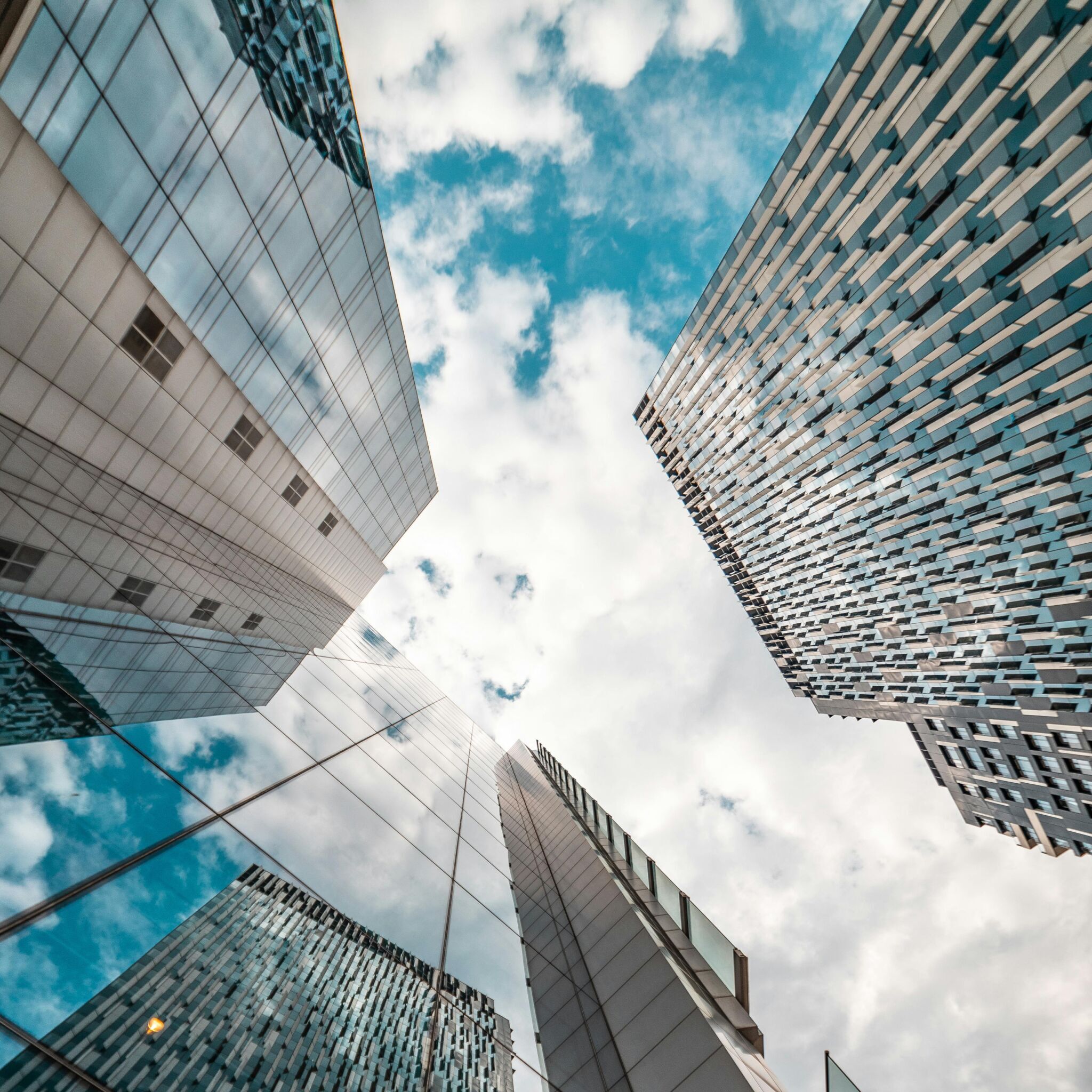 Upward view of modern high-rise buildings, representing commercial real estate advisory